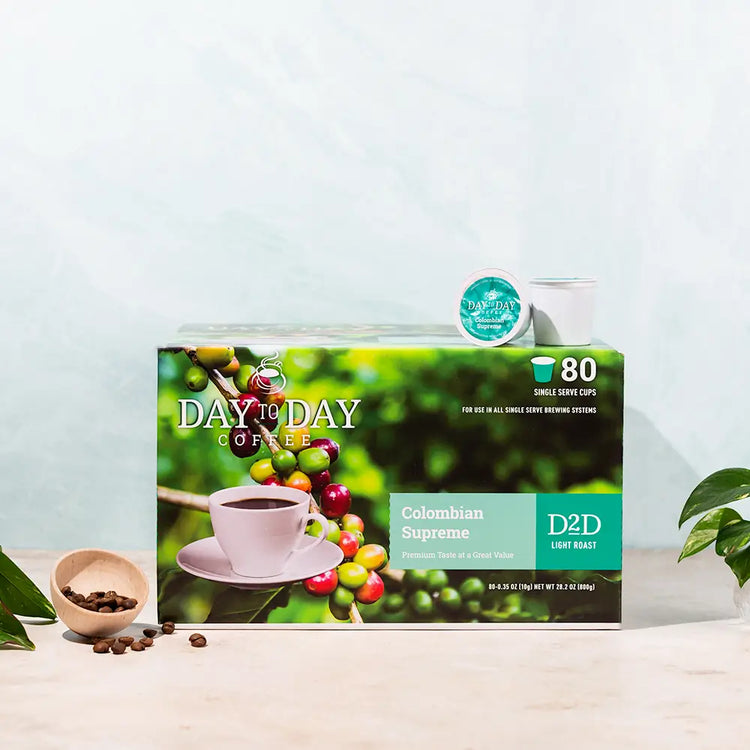 Box of Day to Day Coffee with coffee beans and a cup on a light blue background