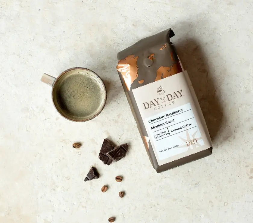 Day to Day Coffee package with a cup of coffee and chocolate pieces on a light surface