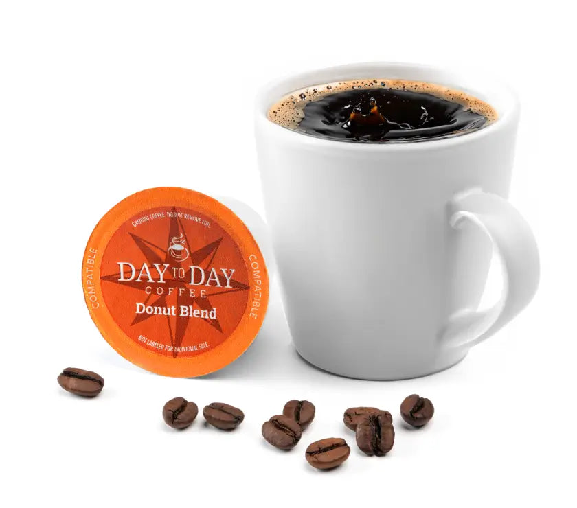 Day to Day Coffee Donut Blend package with a white mug of coffee and scattered coffee beans on a white background