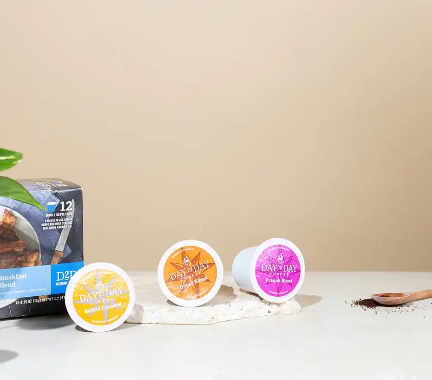 Three Day 2 Day coffee pods on a white surface with a beige background