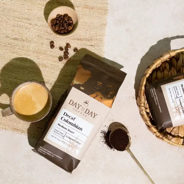 Day by Day Coffee packages with a cup of coffee and coffee beans on a textured surface