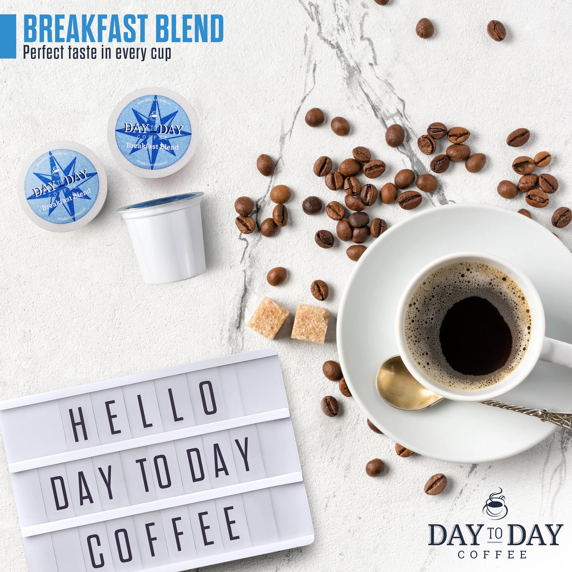Flat lay of Day to Day Coffee Breakfast Blend K-Cup pods with Hello Day to Day Coffee sign, beans, and sugar cubes